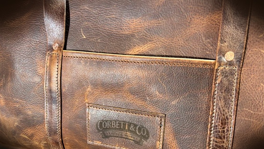 Close-up of the embossed Corbett & Co. Leather Works maker's mark on a handcrafted leather bag