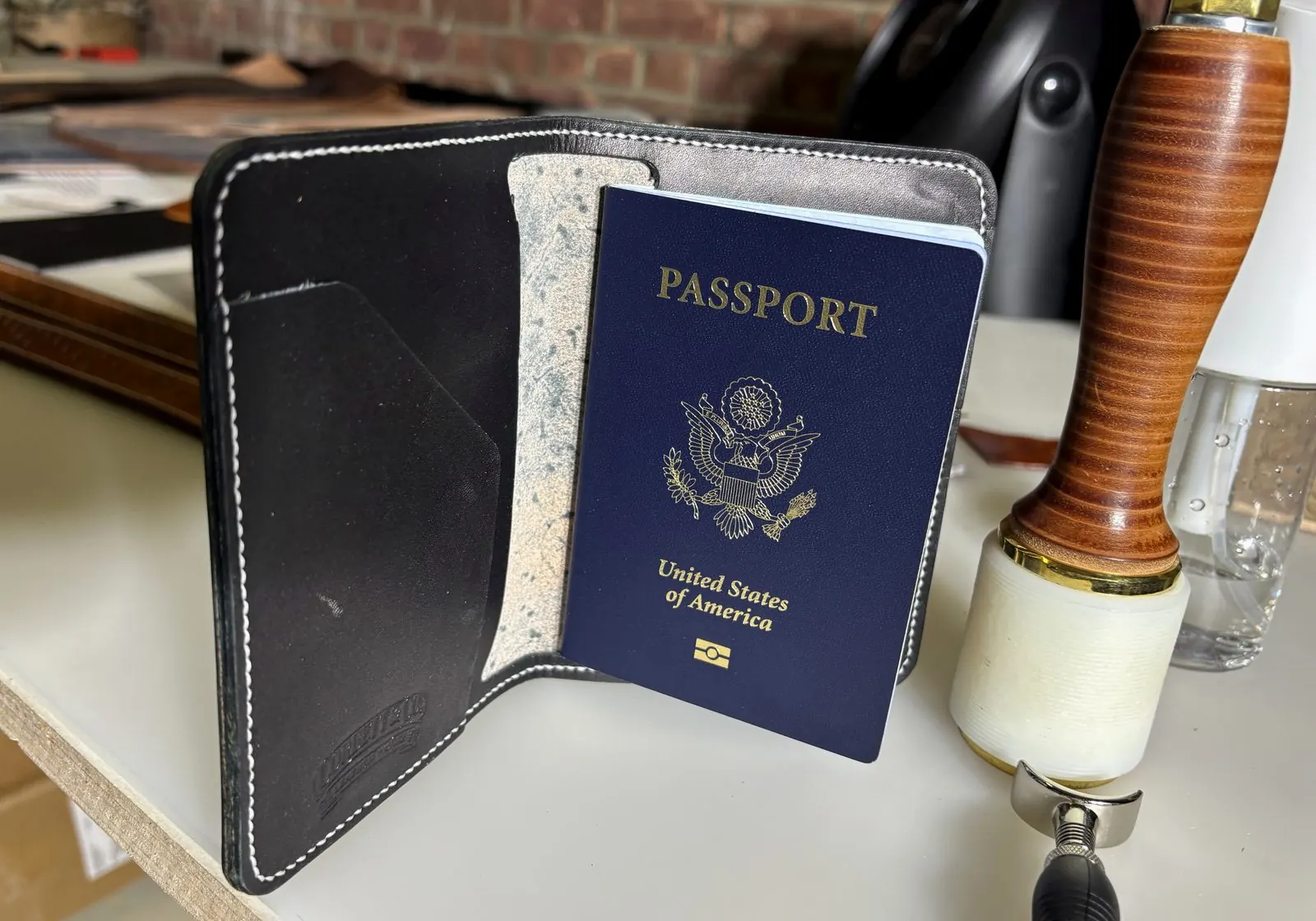 Open passport wallet with U.S. passport, card slots, and maker's mark