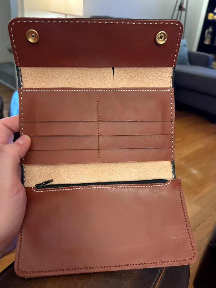 Open leather clutch with eight card slots, zip pocket, and two snap fasteners