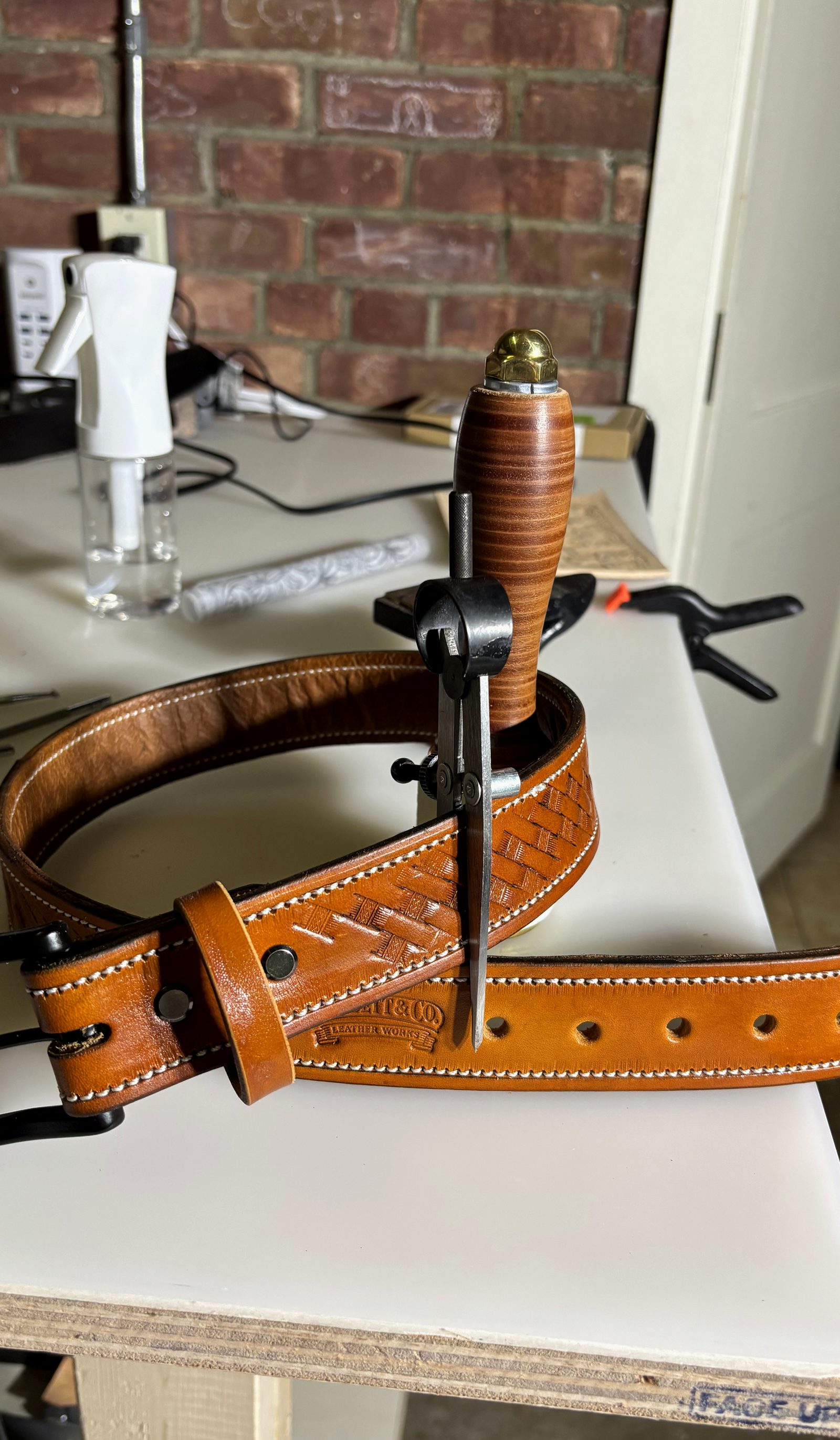The Heritage Belt buckle detail with brand stamp and basketweave tooling