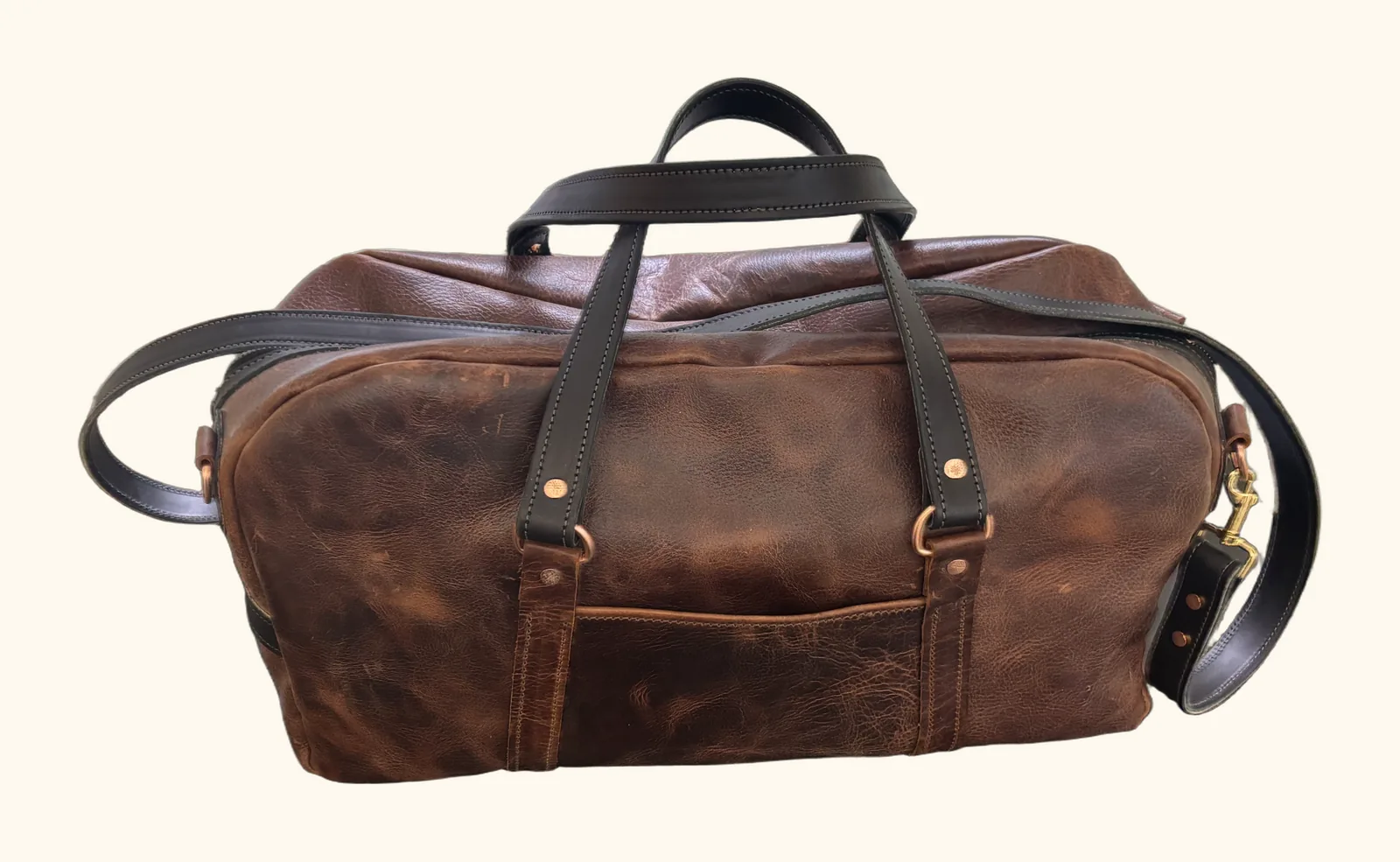 Handcrafted pull-up leather weekender duffel with black straps and brass hardware