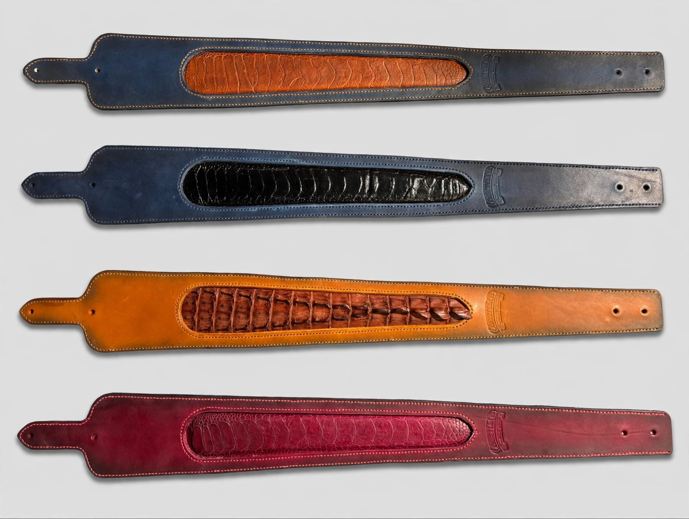 Lineup of handmade leather rifle slings with ostrich inlay