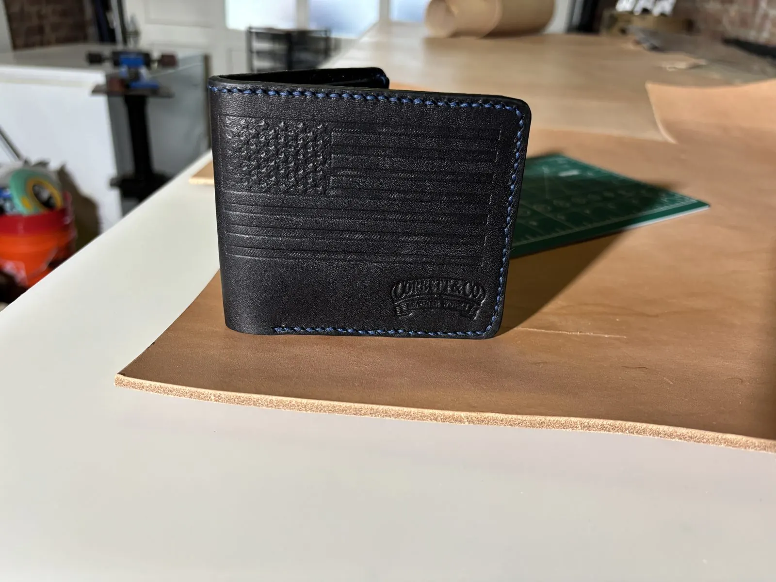 Embossed flag bifold on the workbench with Corbett & Co. maker's mark