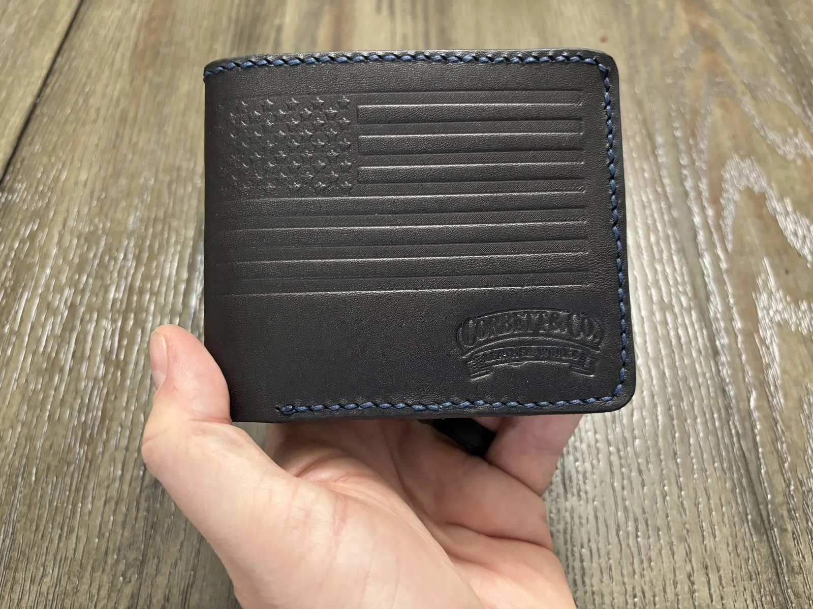 Black leather bifold with embossed American flag and contrast stitching